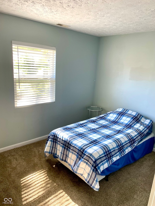 carpeted bedroom featuring a textured ceiling