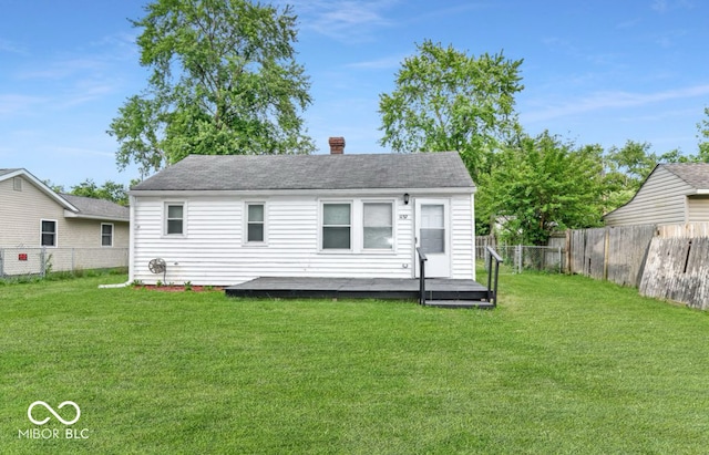 back of property with a lawn and a wooden deck