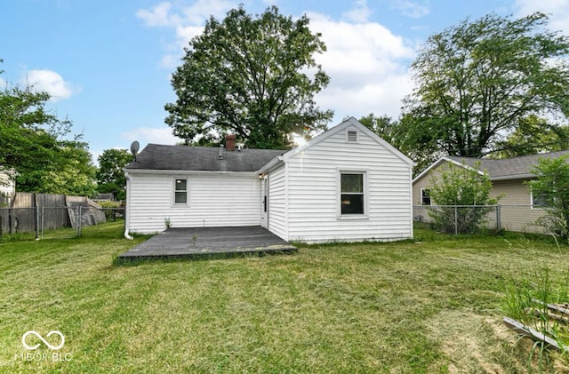 back of property with a wooden deck and a yard