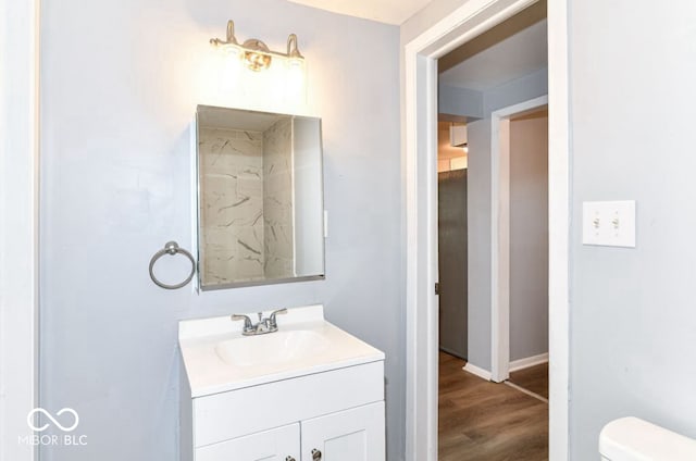 bathroom with hardwood / wood-style flooring, vanity, and toilet