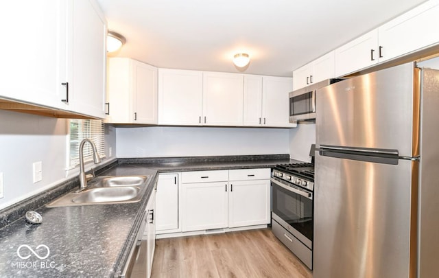 kitchen with light wood-type flooring, white cabinetry, sink, and stainless steel appliances