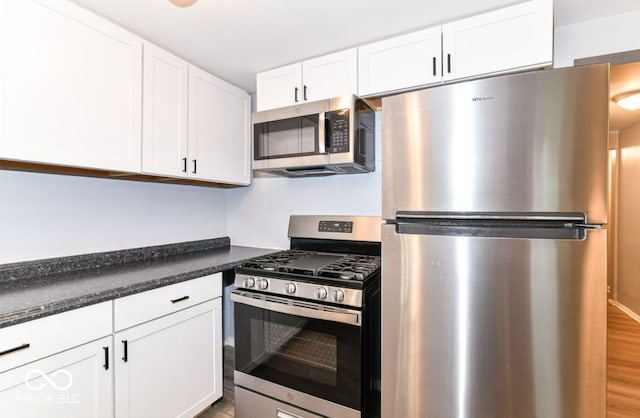 kitchen with wood-type flooring, stainless steel appliances, and white cabinetry