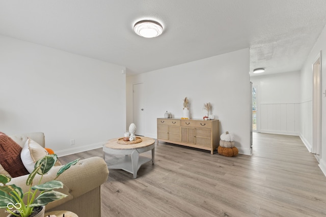 living area with light hardwood / wood-style flooring and a textured ceiling