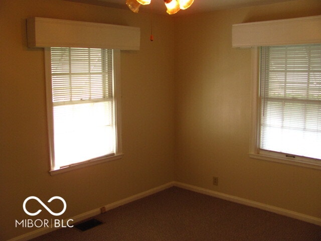 carpeted empty room featuring ceiling fan