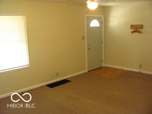 carpeted foyer featuring ceiling fan