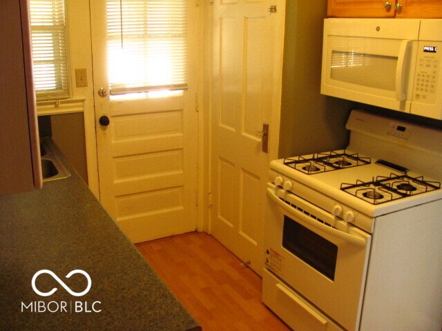 kitchen featuring light wood-type flooring and white appliances