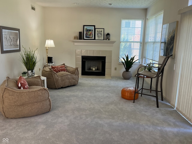 carpeted living room featuring a fireplace and a textured ceiling