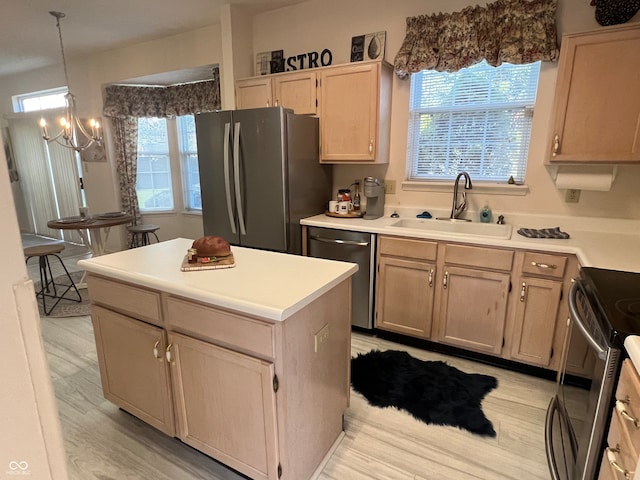 kitchen featuring appliances with stainless steel finishes, light wood-type flooring, sink, light brown cabinets, and a center island