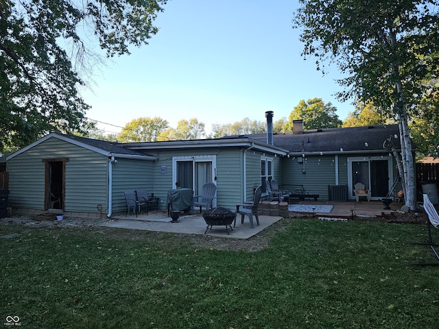 back of house with a lawn, a patio, and a fire pit