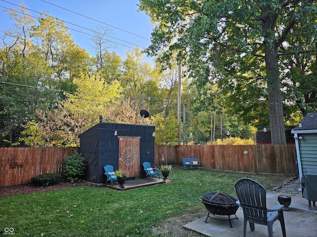 view of yard featuring a storage shed, a patio area, and an outdoor fire pit