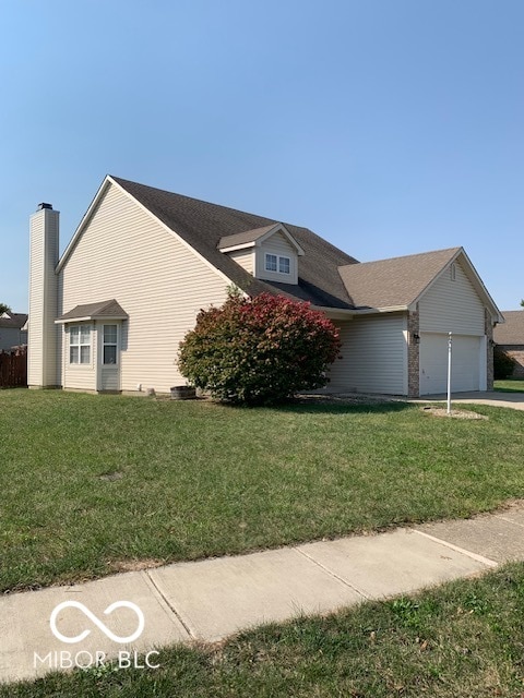 view of front of home featuring a front yard and a garage