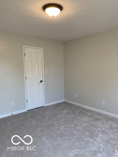 unfurnished room featuring carpet floors and a textured ceiling