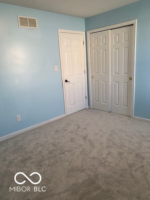 unfurnished bedroom with a closet and carpet