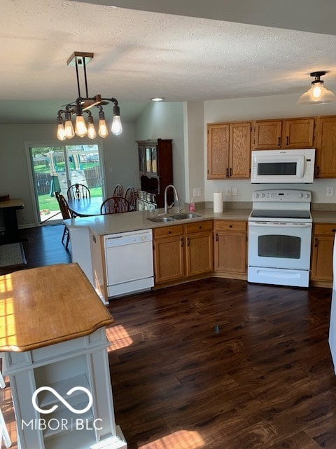 kitchen with a chandelier, pendant lighting, white appliances, sink, and dark hardwood / wood-style floors