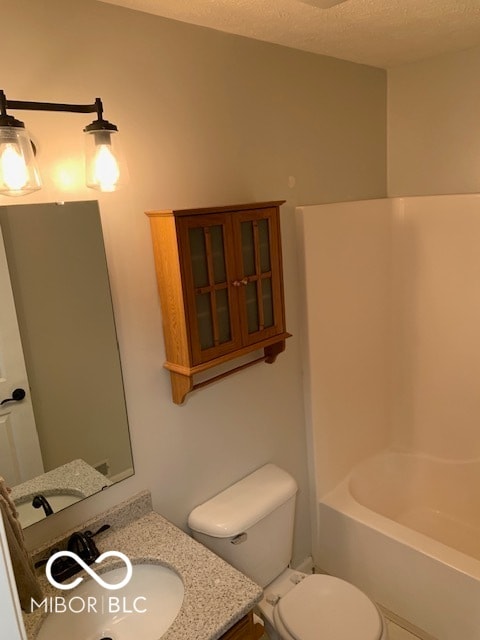 full bathroom with a textured ceiling, shower / bath combination, vanity, and toilet