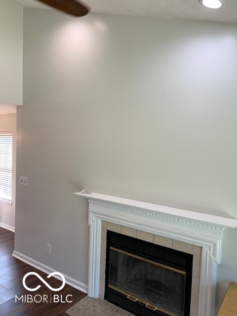 interior details with hardwood / wood-style floors and a tiled fireplace