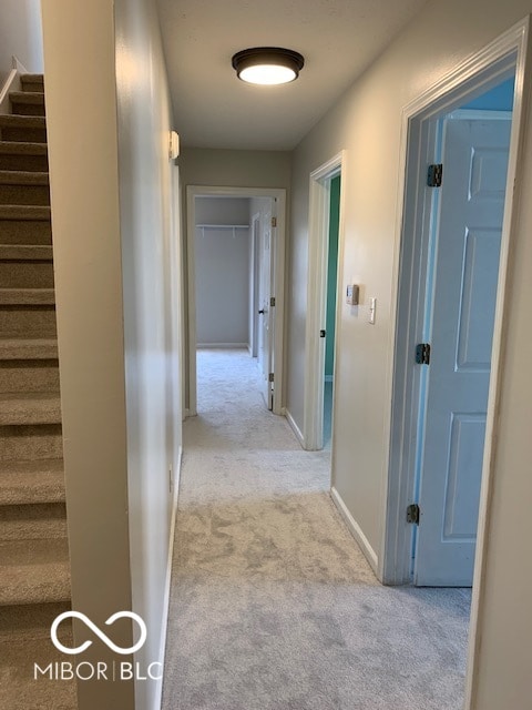 hallway featuring light colored carpet