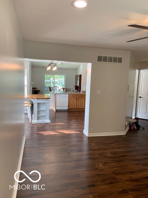 kitchen with ceiling fan with notable chandelier, kitchen peninsula, dark hardwood / wood-style floors, and dishwasher