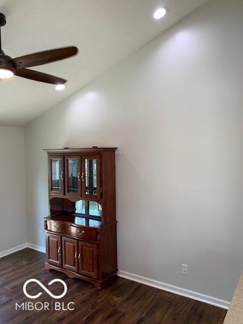 interior space with dark wood-type flooring, vaulted ceiling, and ceiling fan