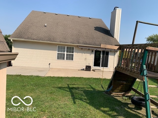 back of house featuring a wooden deck and a lawn