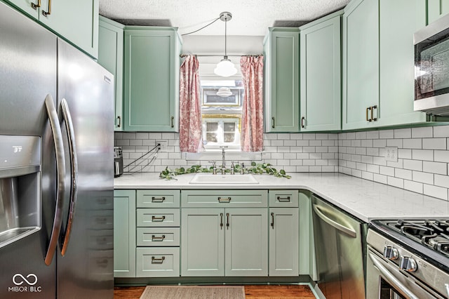 kitchen featuring stainless steel appliances, green cabinetry, and sink