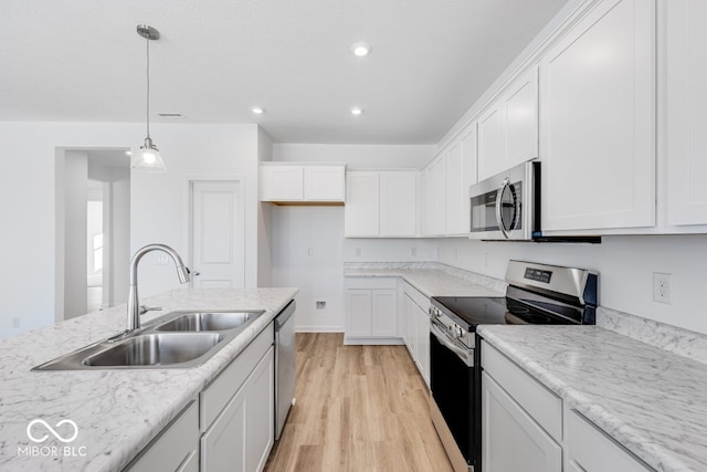 kitchen with stainless steel appliances, sink, hanging light fixtures, and white cabinets