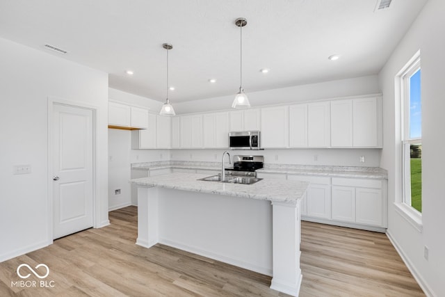 kitchen featuring white cabinetry, sink, a kitchen island with sink, and appliances with stainless steel finishes