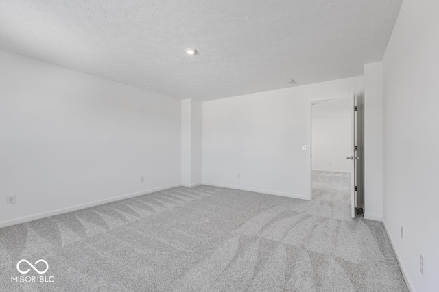 carpeted spare room with a textured ceiling