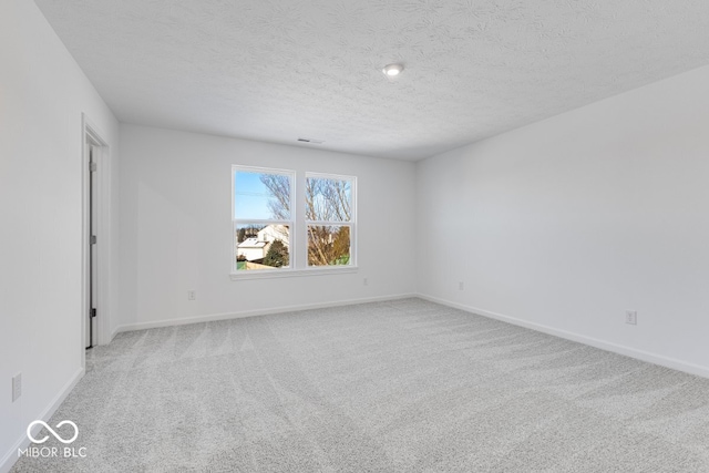 carpeted empty room with a textured ceiling