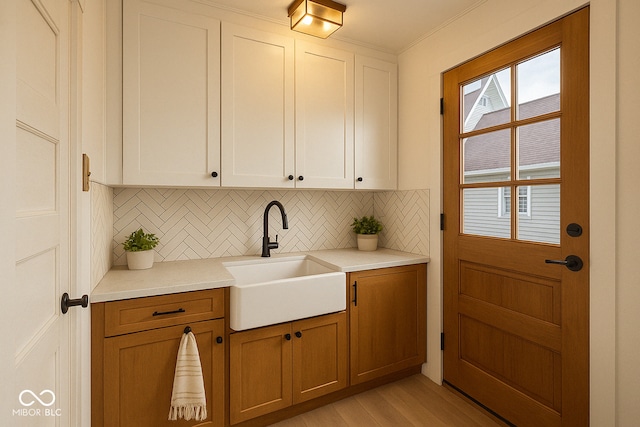 610 E Morgan St, Martinsville, IN 46151 - kitchen featuring a sink, tasteful backsplash, light wood finished floors, light countertops, and white cabinetry