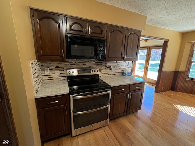 kitchen with wood walls, electric range, and dark brown cabinetry