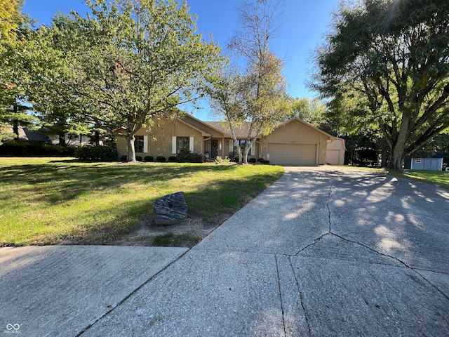 single story home with a garage, a front yard, and an outbuilding