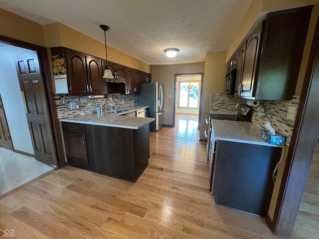 kitchen featuring decorative backsplash, light hardwood / wood-style floors, appliances with stainless steel finishes, and dark brown cabinetry