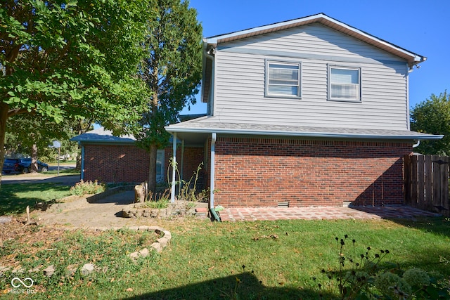 view of side of home with a yard