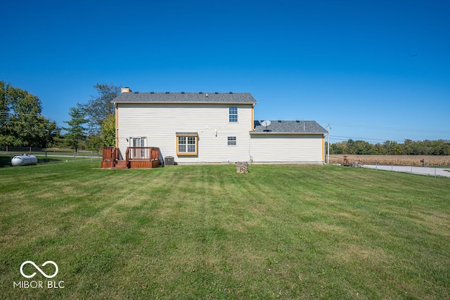 back of property featuring a wooden deck, central AC unit, and a lawn