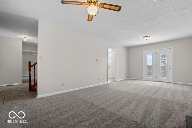 empty room with ceiling fan, carpet flooring, and a textured ceiling