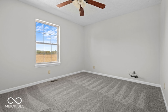 carpeted empty room featuring ceiling fan and a textured ceiling