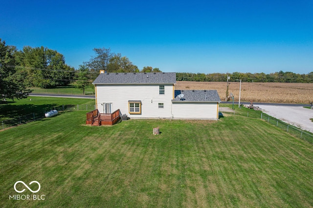 back of property with a wooden deck and a lawn