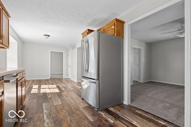 kitchen with stainless steel appliances, a textured ceiling, dark hardwood / wood-style floors, and ceiling fan