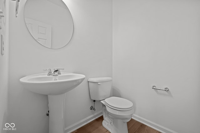 bathroom with hardwood / wood-style floors and toilet