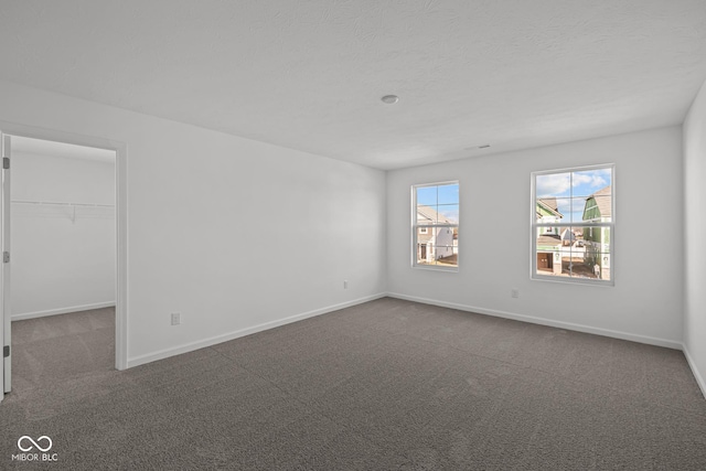 spare room with dark colored carpet