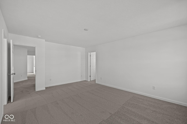 carpeted spare room with a textured ceiling