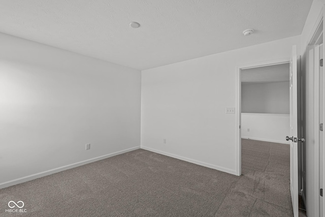 spare room with dark carpet