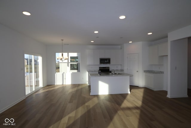 kitchen featuring white cabinets, a notable chandelier, sink, and a kitchen island with sink