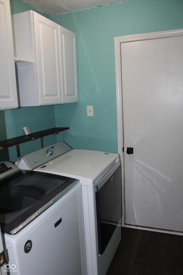 washroom featuring a textured ceiling, cabinets, dark hardwood / wood-style flooring, and separate washer and dryer