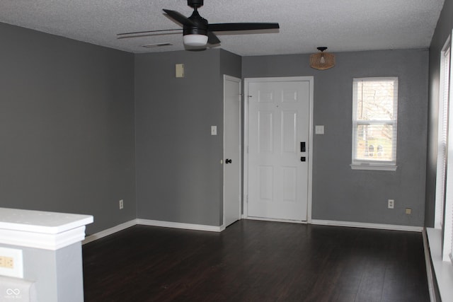 foyer with dark hardwood / wood-style floors, ceiling fan, and a textured ceiling