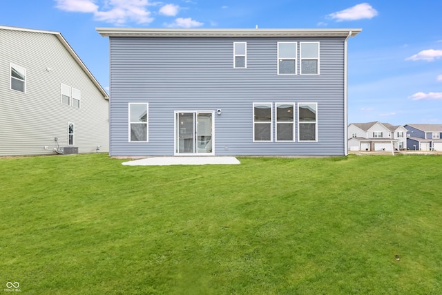 rear view of house featuring a lawn and a patio