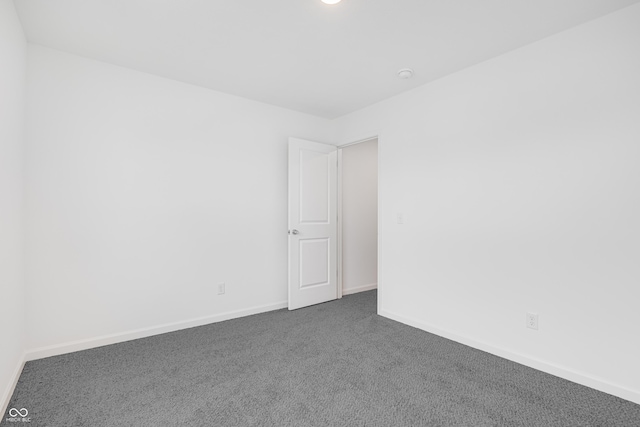 empty room featuring dark colored carpet