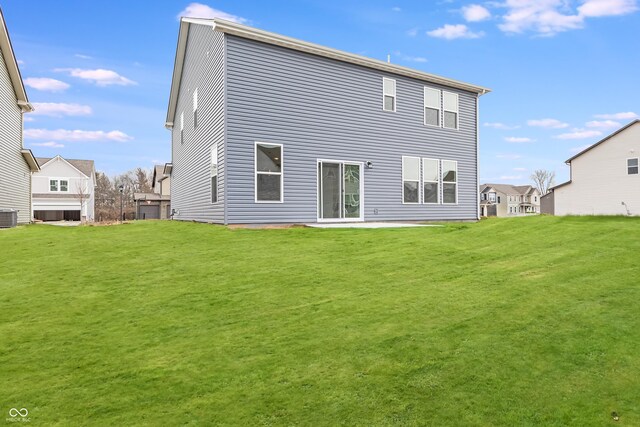 back of house featuring central AC unit and a lawn