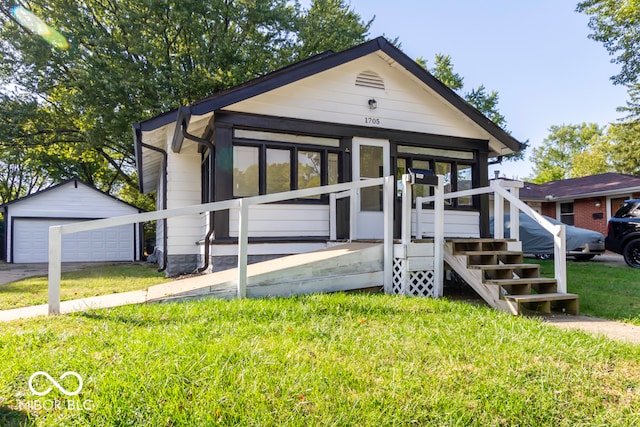 bungalow featuring a front lawn, an outdoor structure, and a garage